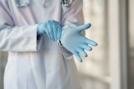 Healthcare worker putting on medical gloves.