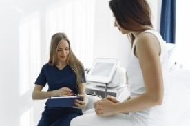 Medical assistant helping patient.