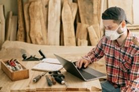man using laptop near hand tools.