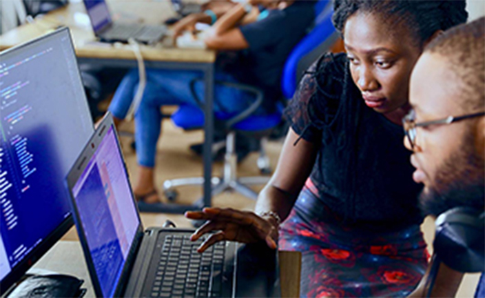 two employees looking at multiple screens.