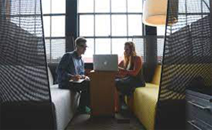 A man and woman working on laptop computer.