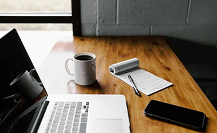 Laptop and coffee on desk.