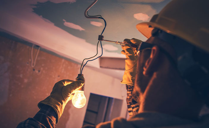 An electrician installing a lightbulb.