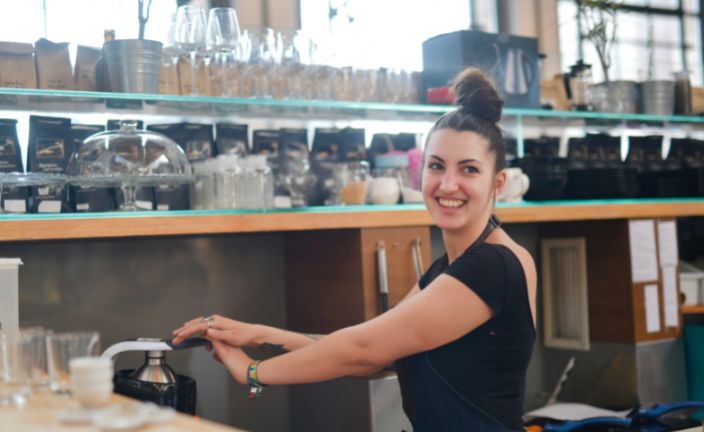 Restaurant worker behind the counter with dishes.