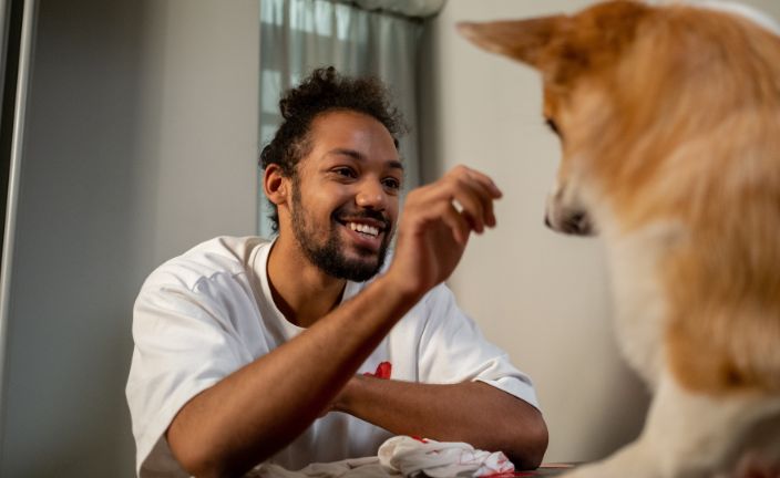 man giving dog a treat.