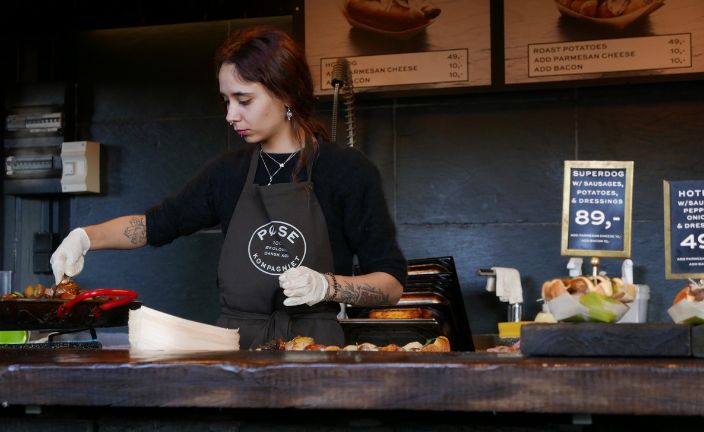 barista arranging pastries at cafe.