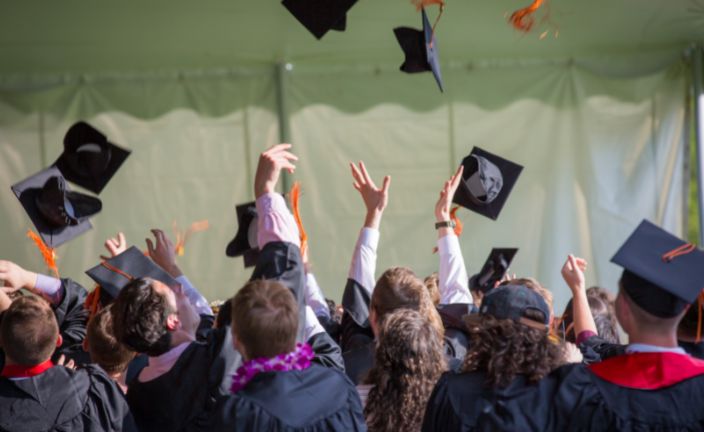 Graduates throwing their grad caps in celebration.