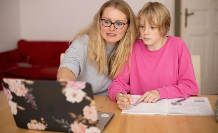 mother helping child with homework.