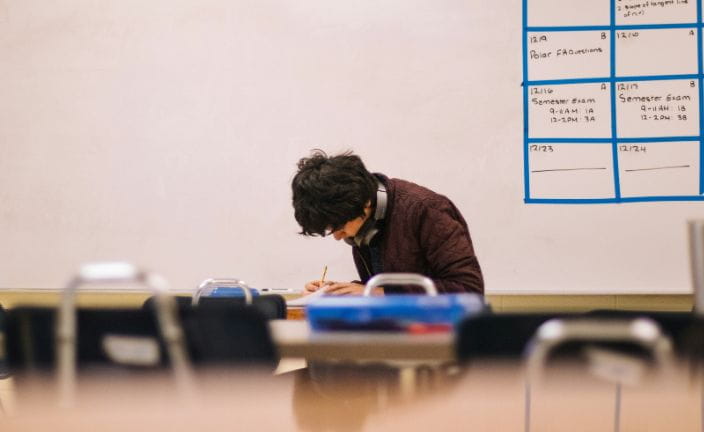 student working alone in a classroom.