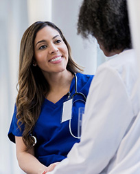 Medical assistant speaking with a doctor.