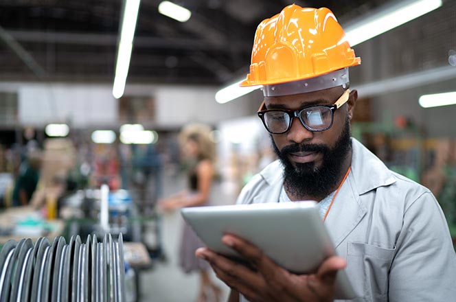 Warehouse technician using an ipad to take notes on a product status.