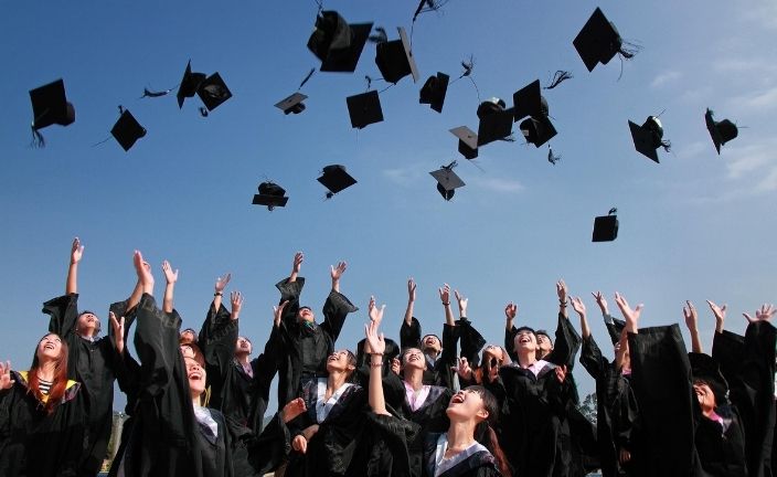 graduates tossing mortarboards.