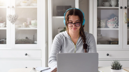 student wearing headphone working on her laptop