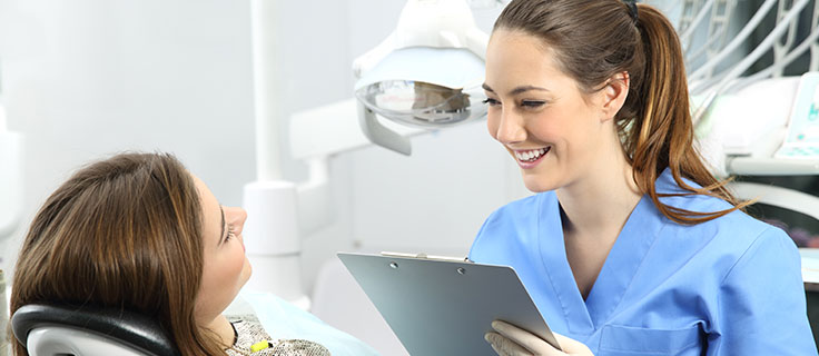 dental assistant talking with patient.