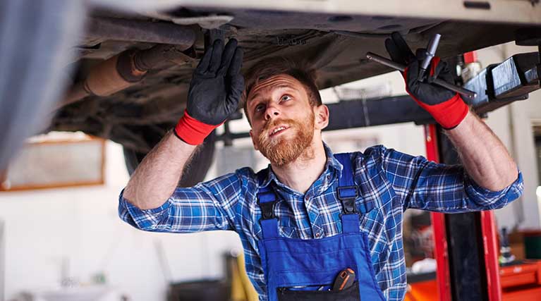 two mechanics inspect truck engine.