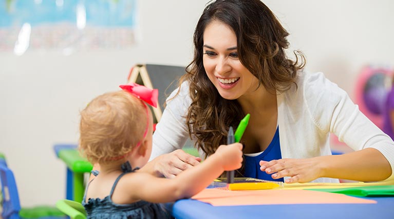 early childhood educator playing with student.