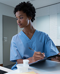 medical records technician reading computer screen and taking notes