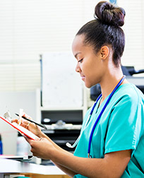 health professional looking at a chart in front of a computer.