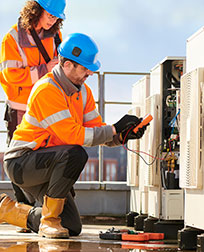 Two HVAC workers installing a commercial A/C.