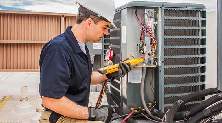 HVACR technician working on commercial air conditioner