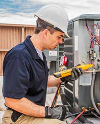 HVACR technician working on commercial air conditioner