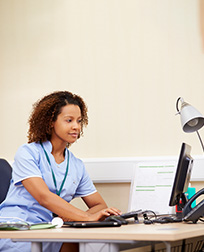 woman sitting behind a desk on a computer.