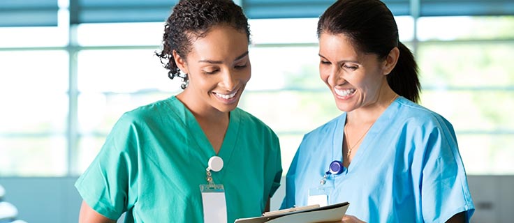 two medical assistants reading charts