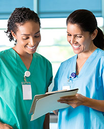 two medical assistants reading charts