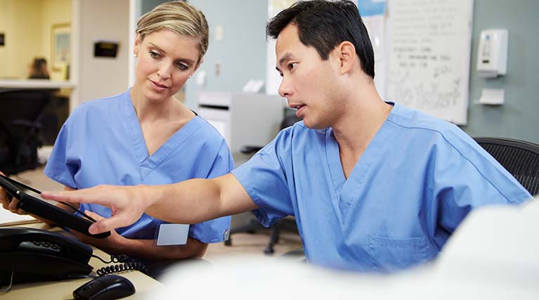 two medical terminologist reading computer tablets.