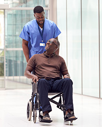 medical professional transporting a patient in a wheelchair.