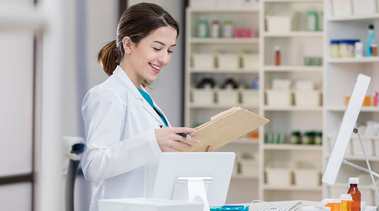 pharmacy technician reading chart in pharmacy
