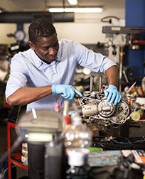 mechanic repairing a small engine in a repair shop.